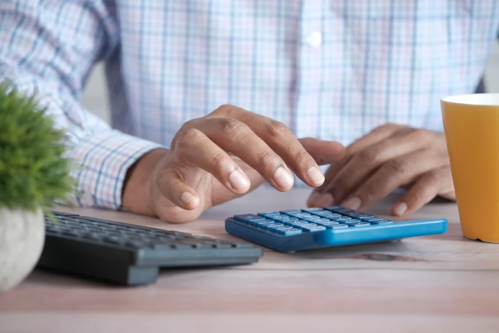 hands typing on calculator to solve IRS problem